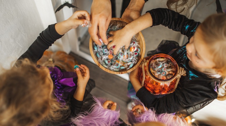 kids in costumes grab candy on halloween