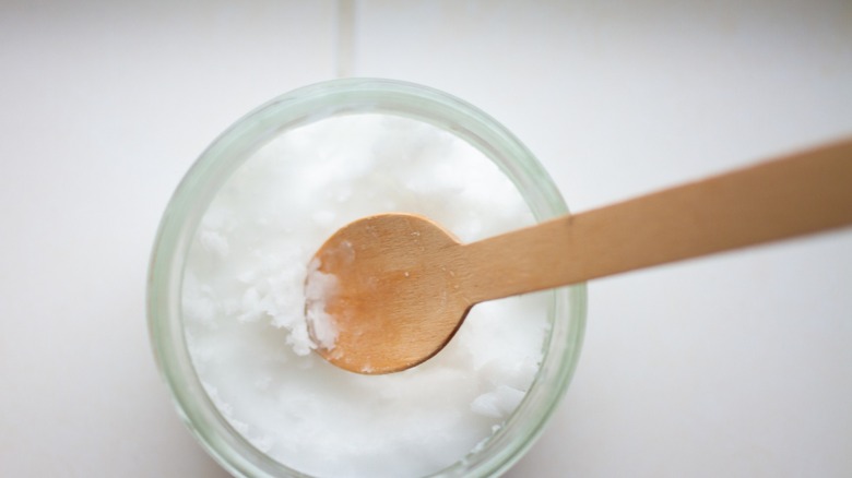 coconut oil with wooden spoon