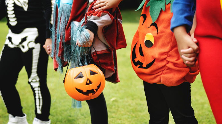 Kids in Halloween costumes holding hands