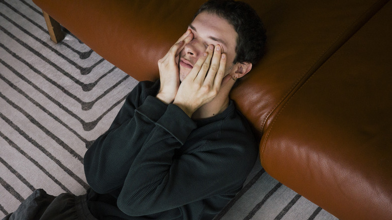 person with headache on floor