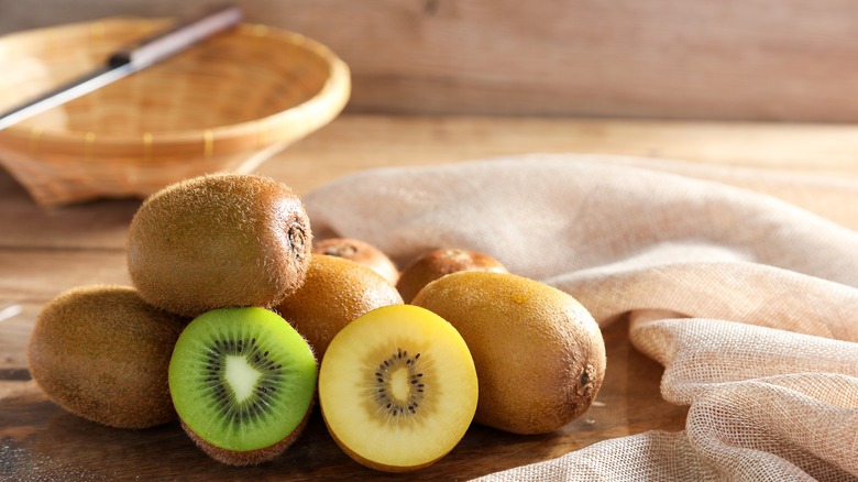 yellow and green kiwifruit on a cutting board