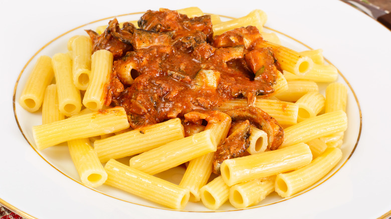 A plate of pasta with sardines and tomato sauce