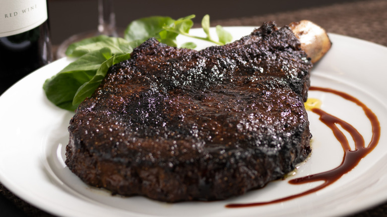 bone-in ribeye steak from The capital grille, closeup on white plate