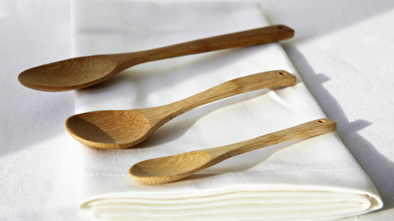 three wooden spoons resting on white napkin