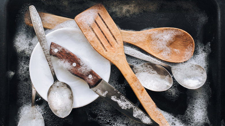 wooden utensils being washed in soapy water