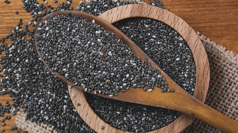 Black and white chia seeds in a wooden spoon