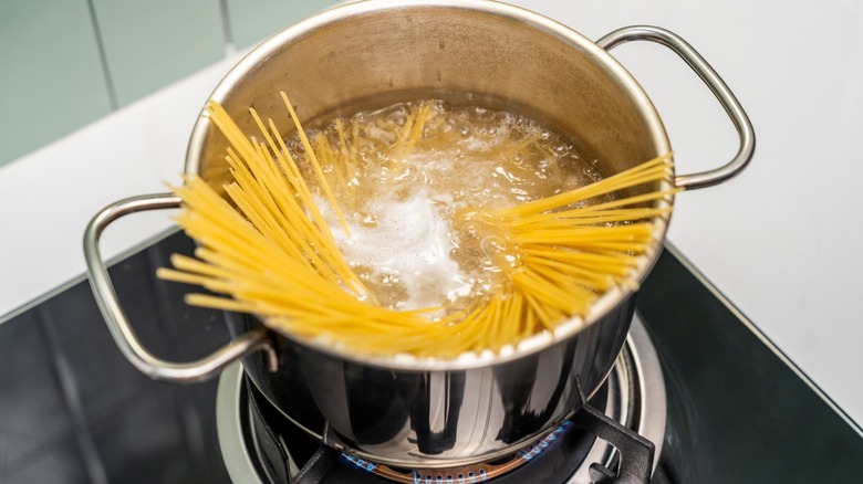 spaghetti noodles in pot of boiling water on stovetop