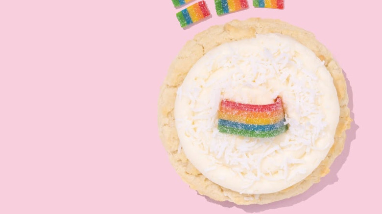 Crumbl Coconut Cake cookie with rainbow candy on pink background