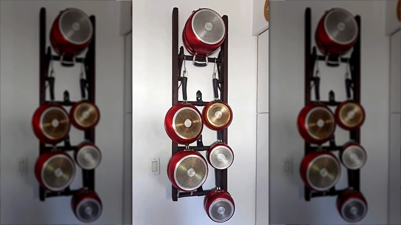 pots and pans hang on hooks from repurposed ladder