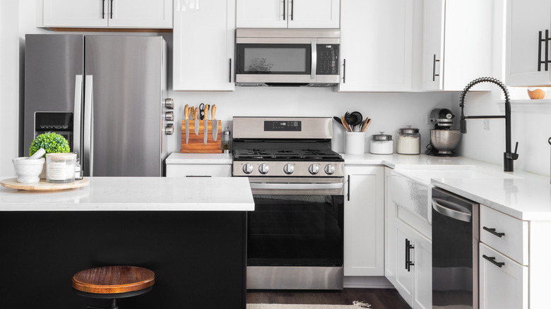 Interior view kitchen with white cabinets and stainless steel appliances.