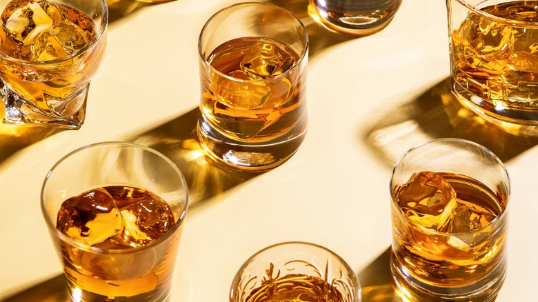glasses of bourbon or whiskey against a pale yellow background