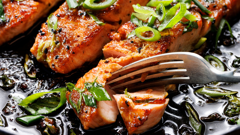 Close-up view of teriyaki salmon sprinkled with chopped scallions
