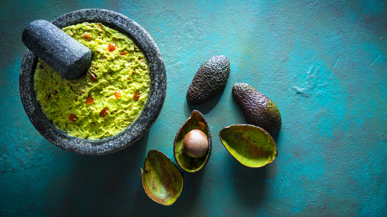 Guacamole in a mocaljete with avocado skins and pit