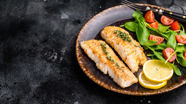 cod filets on plate with tomato salad