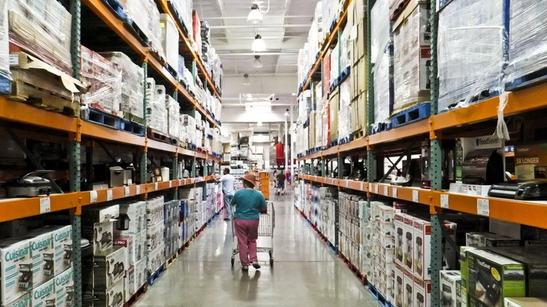 a shopper strolls the aisle at a costco warehouse