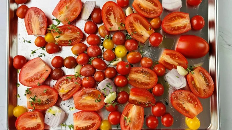 roasted tomatoes and aromatics on sheet tray