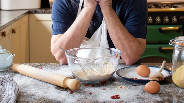 A home baker is overwhelmed in a messy kitchen