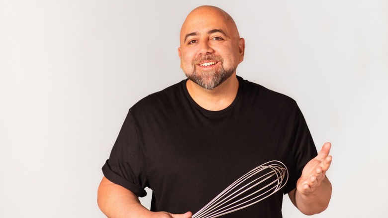 Duff Goldman holding a metal hand whisk