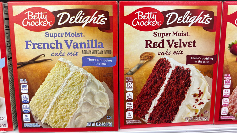 Boxed cake mixes on supermarket shelf.