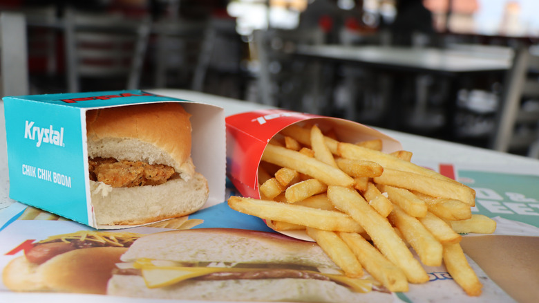 Krystal slider and fries on table, with branded packaging.