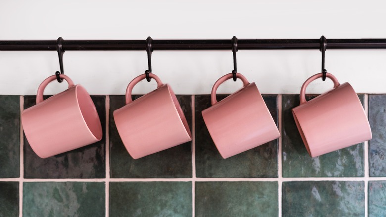 Pink coffee mugs hanging.