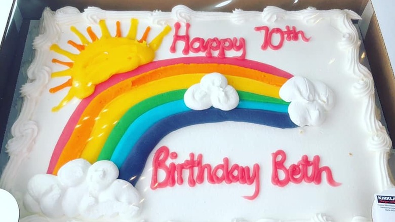 A close-up of a Costco custom birthday cake with a rainbow design