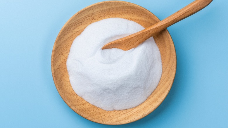 bowl of white baking powder with wooden spoon