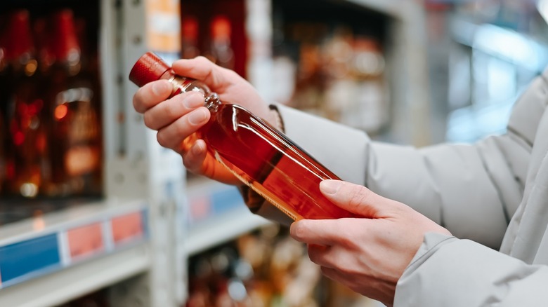 Close-up of someone holding a bottle of cognac