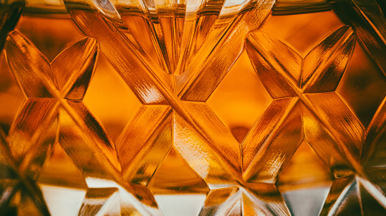 An extreme close-up of whiskey in a cut-glass tumbler