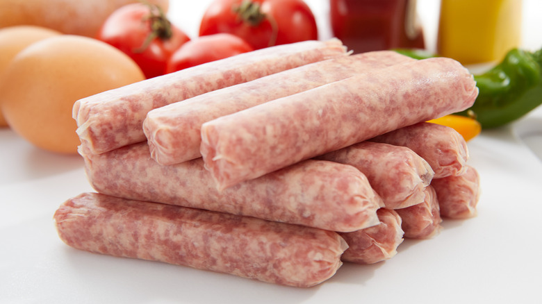 A close-up of a stacked pile of uncooked sausages