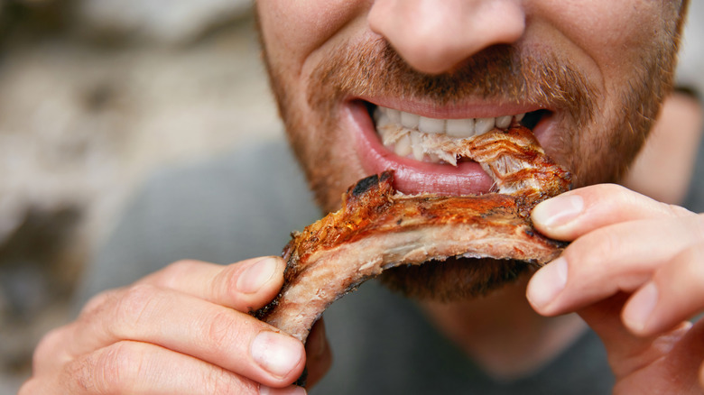 Person eating bbq ribs closeup