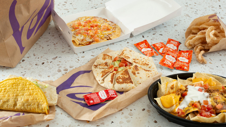 A spread of various taco bell menu items and sauce packets.