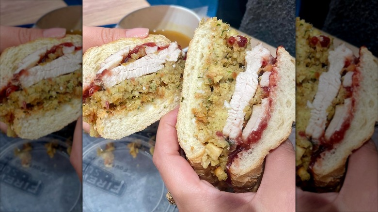 hands hold two halves of a turkey sub