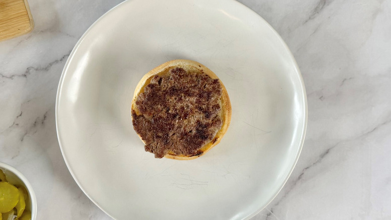 burger patty on a bun on a white plate