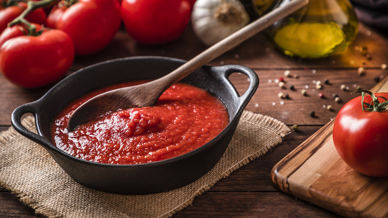 pot filled with tomato sauce surrounded by tomatoes