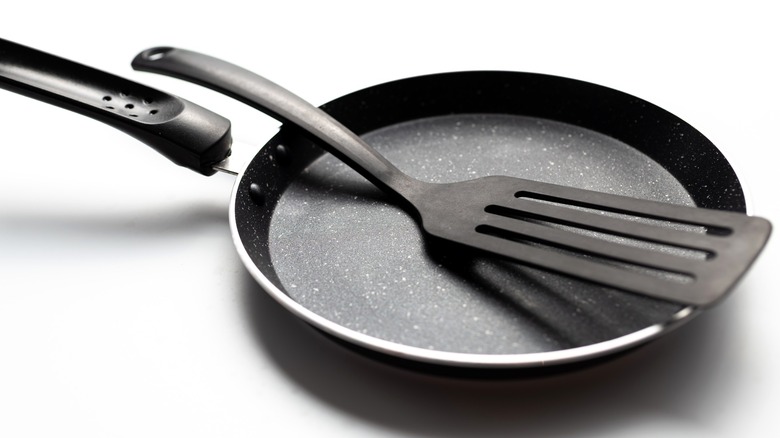 Plastic fish spatula in non-stick frying pan