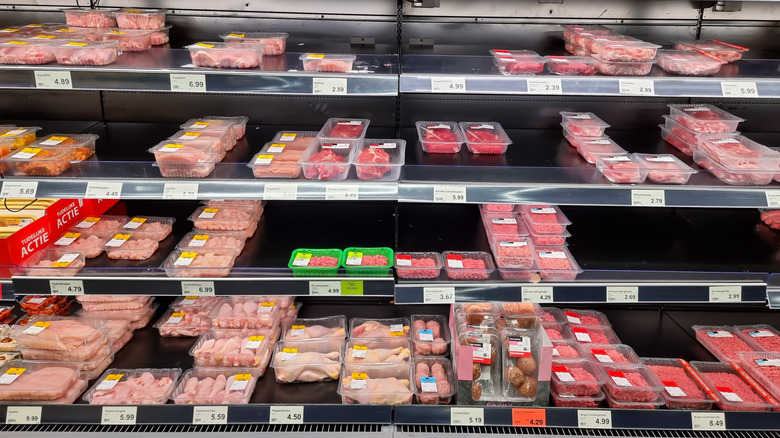 Variety of packaged chicken meat in fridge at an Aldi location.