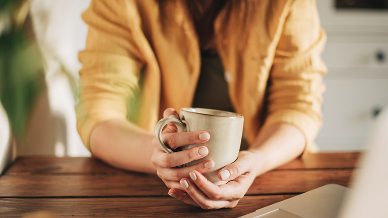 hands holding mug of coffee