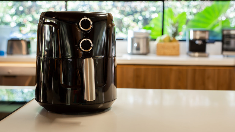 Black air fryer on white kitchen counter