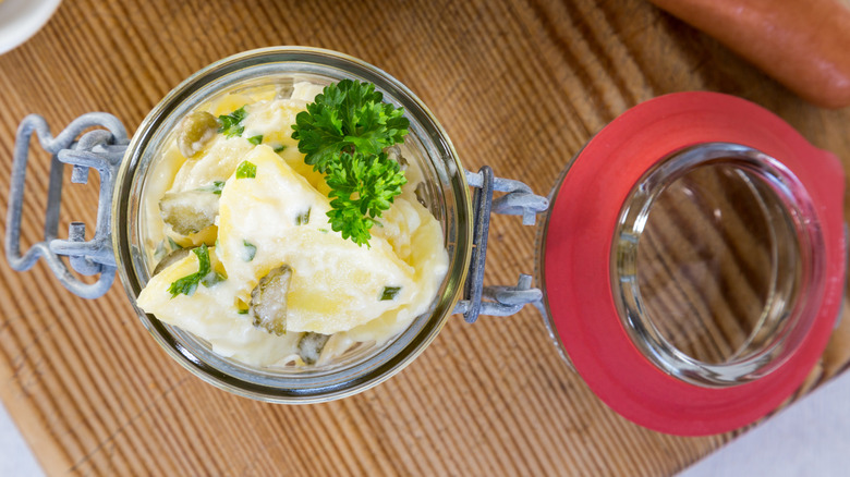 Potato salad in a jar on wooden board