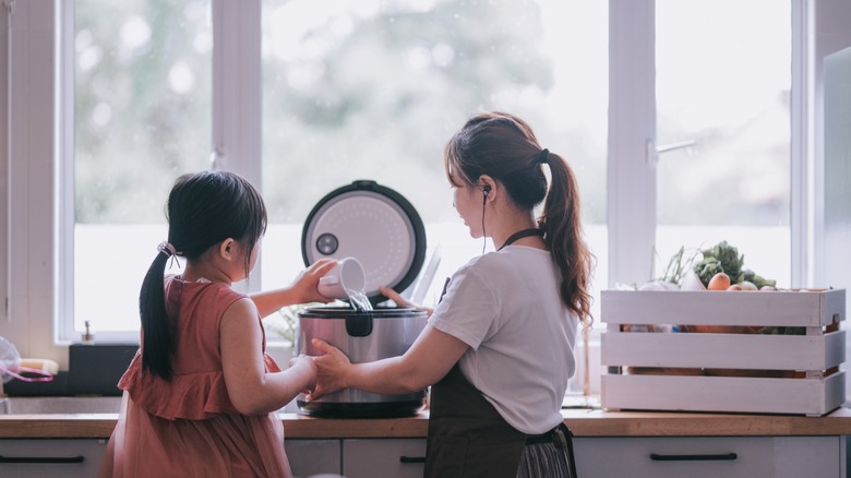 woman and child use rice cooker