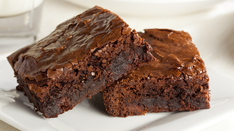 Two home-made chocolate brownies on a white plate