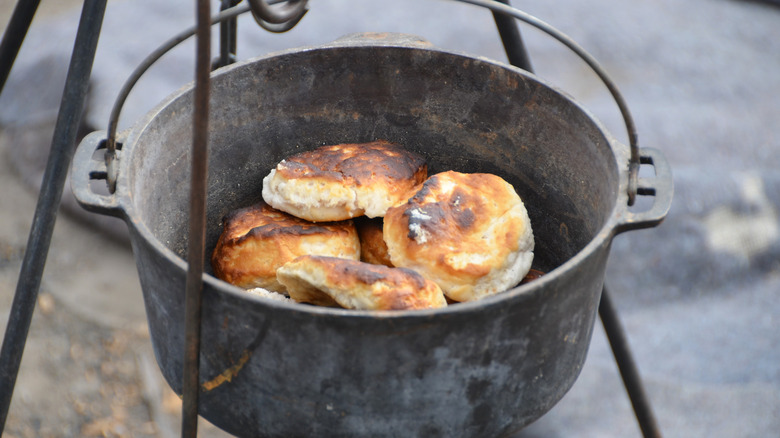 Old cast iron kettle cooking biscuits over a hot fire