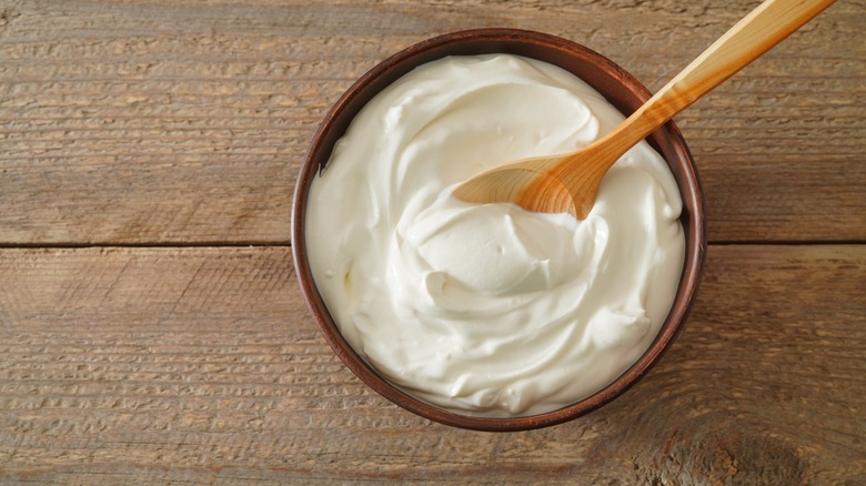 sour cream in bowl with wooden spoon