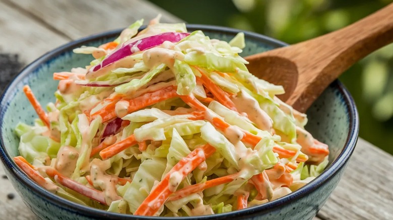 close-up on traditional coleslaw with wooden spoon
