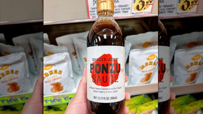 Someone holding a bottle of Trader Joe's ponzu sauce