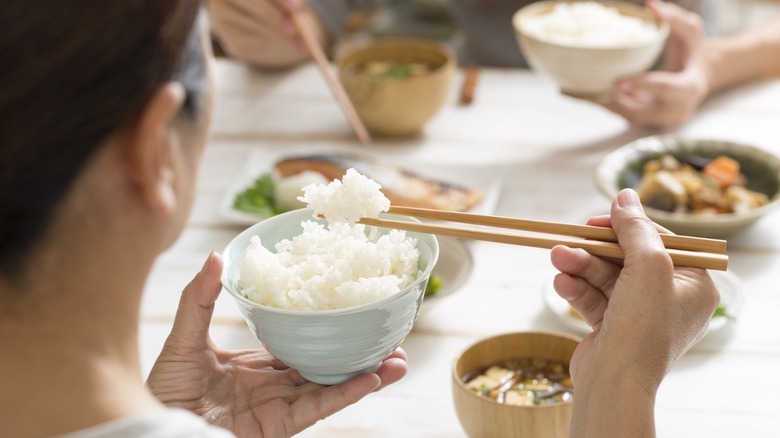 person eating rice with chopsticks