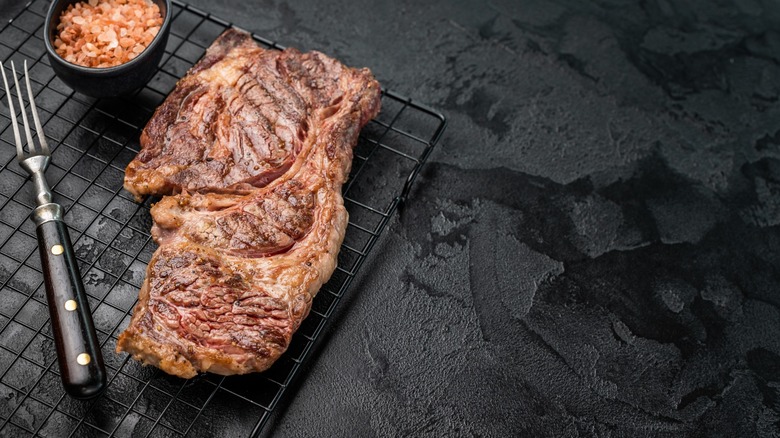 cooked prime rib on roasting rack with fork