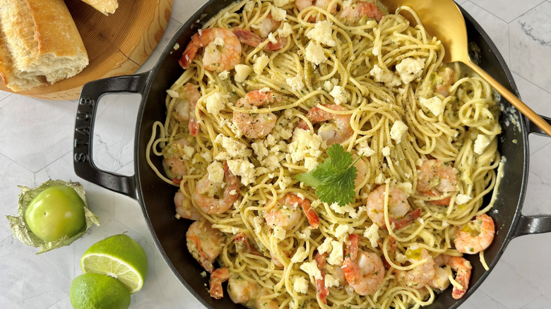 garlic prawn and tomatillo pasta with garnishes in skillet