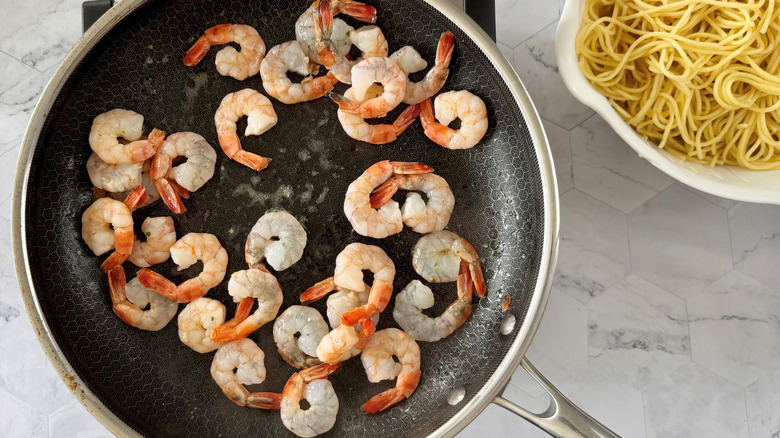 pink cooked prawns in saute pan